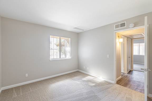a bedroom with hardwood floors and grey walls
