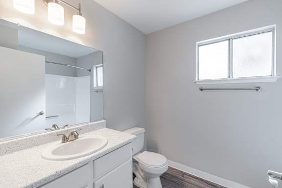 a bathroom with a toilet sink and mirror