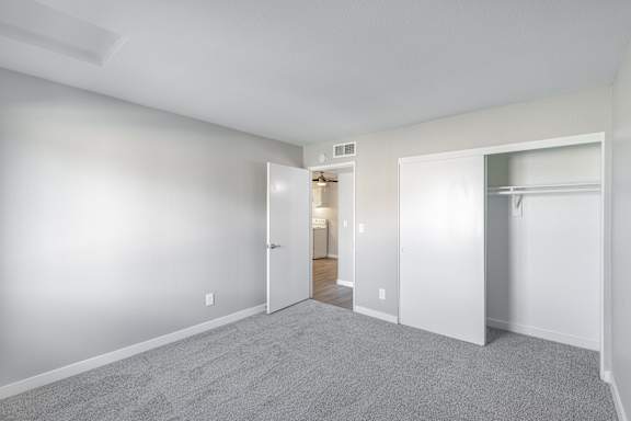 a bedroom with grey carpet and white walls