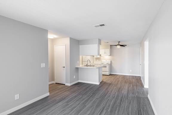a spacious living room with a kitchen in the background
