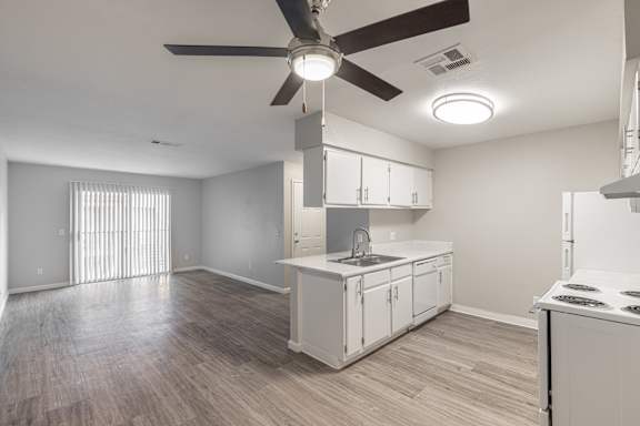 a kitchen and living room with a ceiling fan