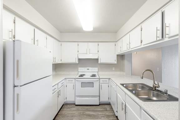 a kitchen with white cabinets and white appliances