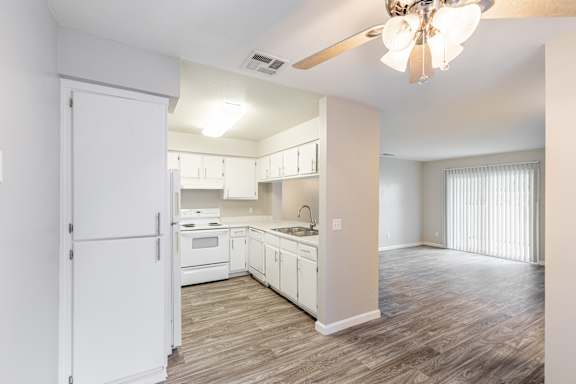a kitchen and living room with a ceiling fan
