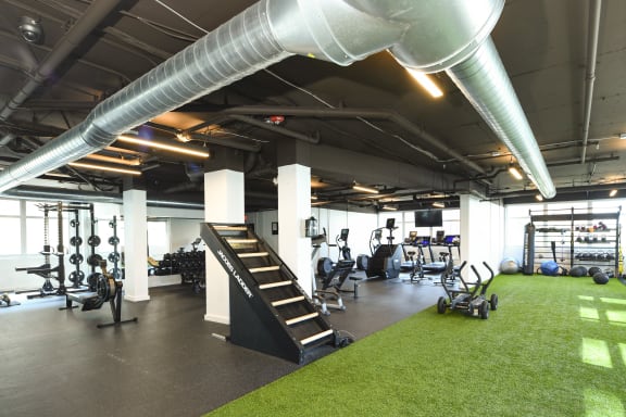 a workout room with weights machines and grass in the middle of the floor