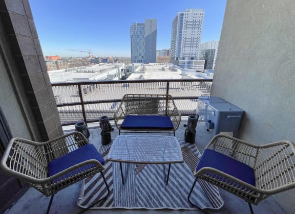 a balcony with a table and chairs and a city in the background