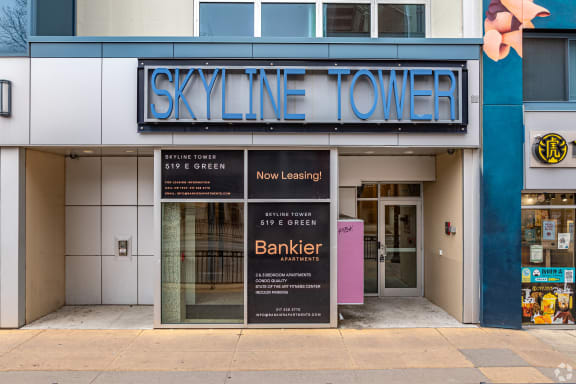 the facade of the skylite tower building with two signs in front of it