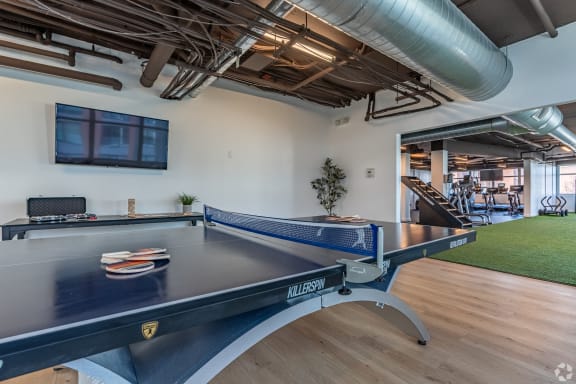 a games room with a ping pong table and a television