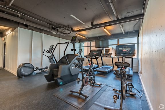 a workout room with weights and cardio equipment in a building