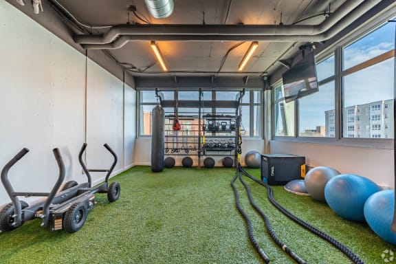 a workout room with weights and other exercise equipment in a building with large windows