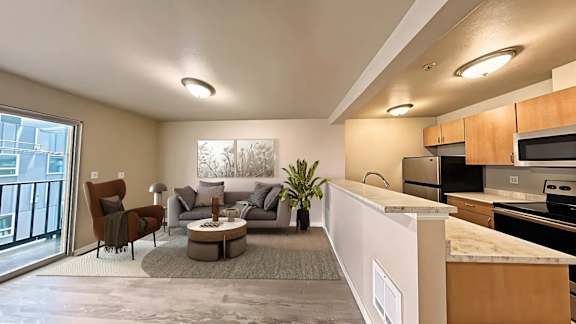 A modern living room with a kitchen area in the background.