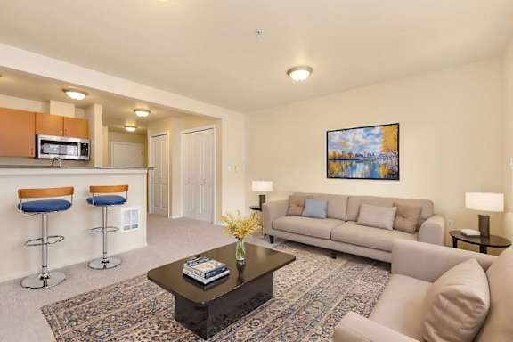 A living room with a sofa, two chairs, a coffee table, and a painting on the wall.