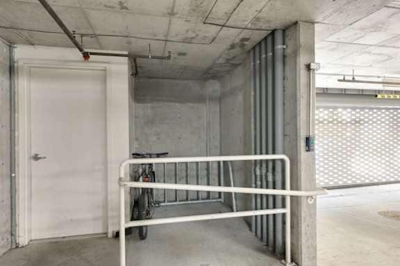 A bicycle is parked on a bike rack in a concrete garage.