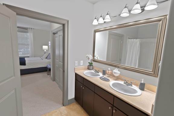 A bathroom with a vanity, two sinks, and a mirror. at The Estates at Ballantyne, Charlotte, 28277