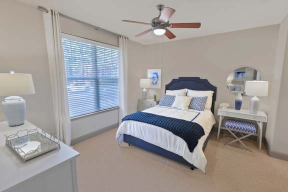 A bedroom with a bed, nightstands, and a ceiling fan. at The Estates at Ballantyne, Charlotte, 28277