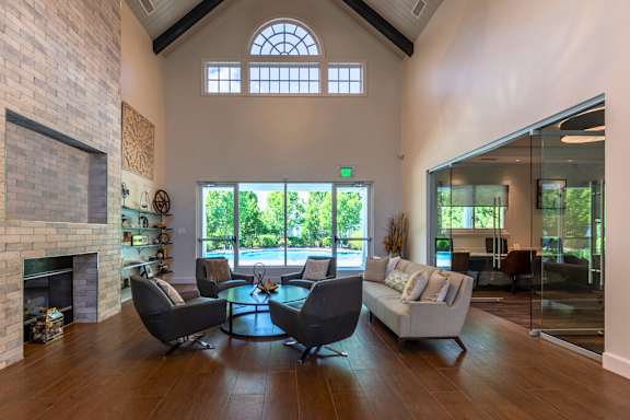 A living room with a fireplace and a glass table.