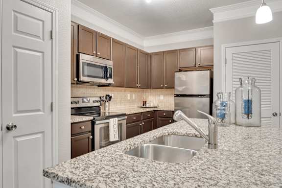 A kitchen with brown cabinets and a granite countertop. at Echo at Lake Norman, Mooresville, NC
