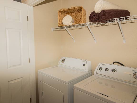 a small laundry room with a washer and dryer and a shelf at Echo at Lake Norman, Mooresville, NC