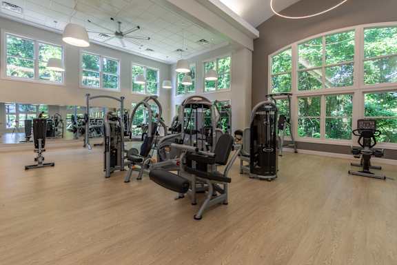 A gym with a variety of equipment and a large window.