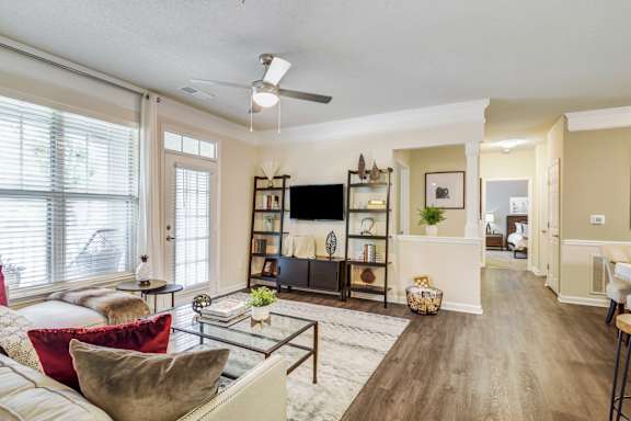 A living room with a white couch and a glass coffee table.