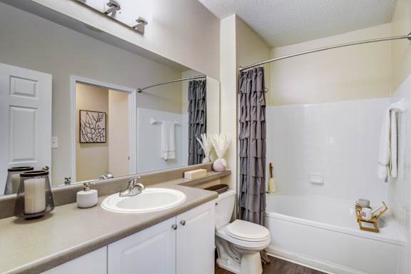 A bathroom with a toilet, sink, and bathtub.