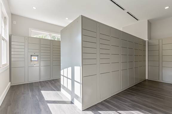 A room with a grey floor and a grey partition with a white sign on it.