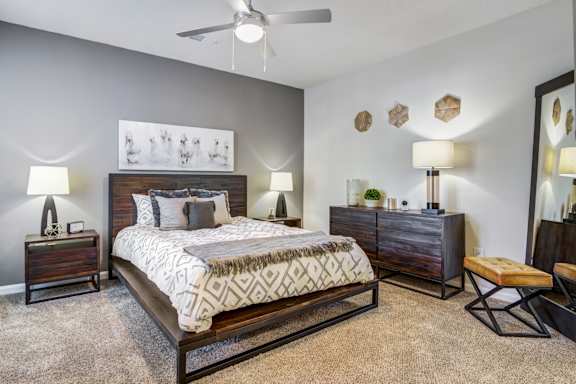 A bedroom with a bed, nightstands, and a bench.
