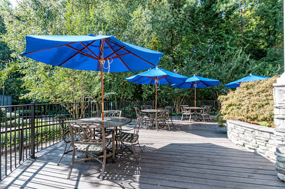 A patio with tables and chairs and umbrellas.