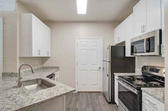A kitchen with a sink, refrigerator, and stove.