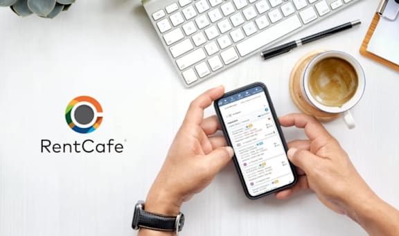 A person is using a smartphone with the RentCafe logo displayed on the screen.