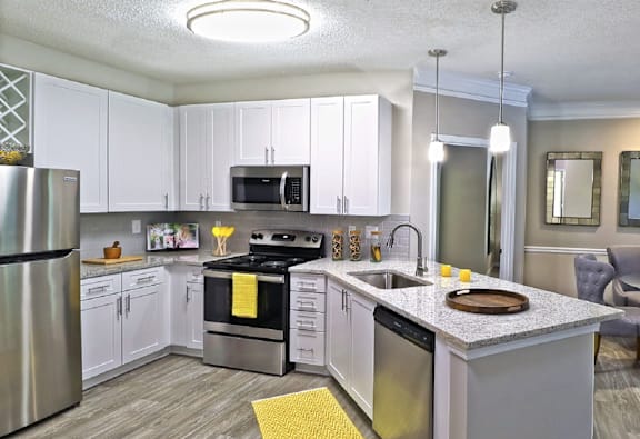 A modern kitchen with a stainless steel refrigerator, oven, and microwave.
