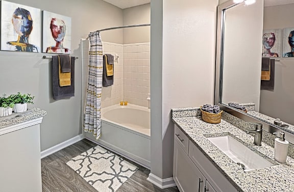 A bathroom with a white tub and a grey counter.