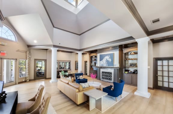 A spacious living room with a skylight, a blue sofa, and a fireplace.