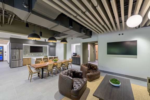A modern open plan living and dining area with a kitchen in the background.