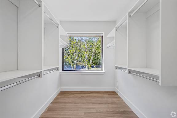 A long, narrow hallway with white walls and wood flooring.
