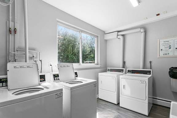 A laundry room with washing machines and a window at Rose Hill Estates, Norwich, CT, 06360