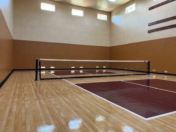 A tennis court in a room with a net at Dominion Courtyard Villas, Fresno