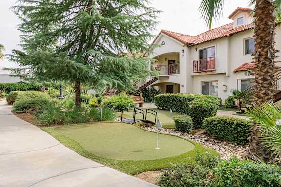 A small putting green in front of a building.