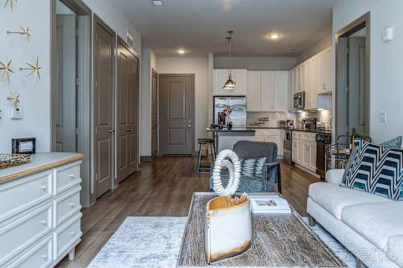 A modern kitchen with a dining area and a living room.