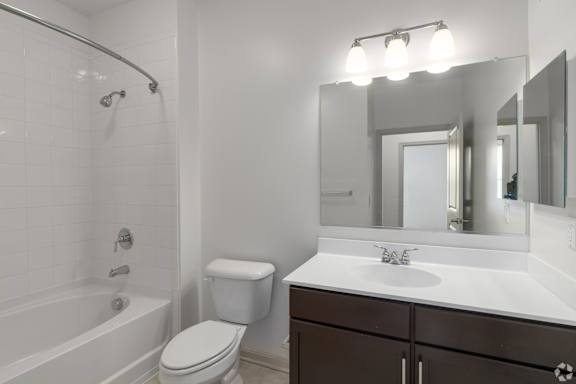 A white bathroom with a toilet, sink, and bathtub.
