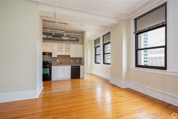 A kitchen area with wooden floors and white walls.