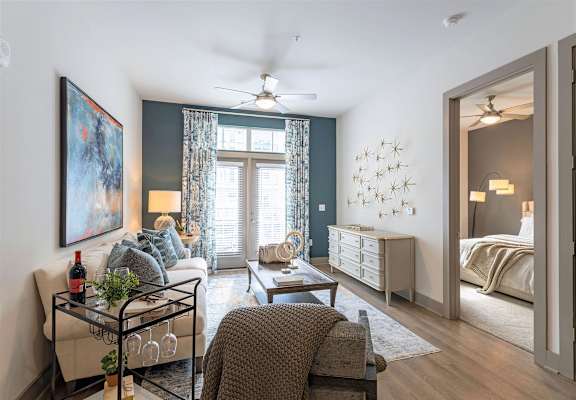 A living room with a couch, a chair, a coffee table, and a painting on the wall.