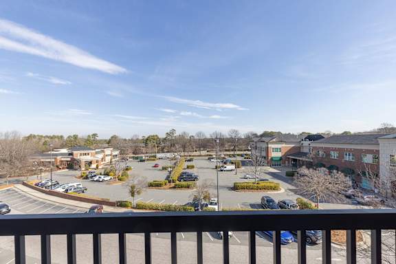 A parking lot with several cars and a building in the background.