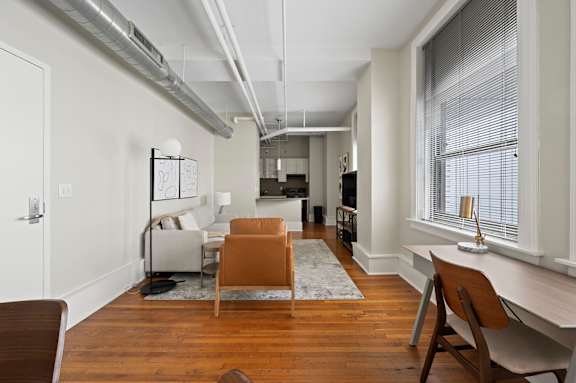 A room with a brown chair and a white desk.