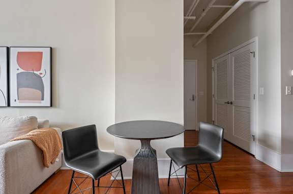 A living room with a grey table and two chairs.