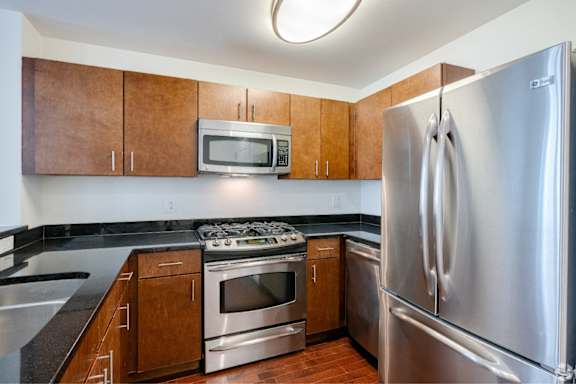 A kitchen with a stove, oven, microwave, and refrigerator.