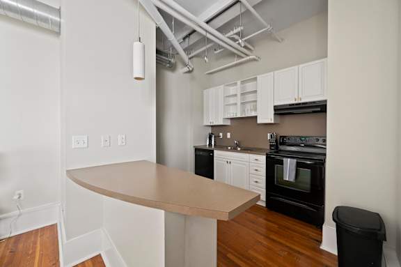 A kitchen with a black oven and white cabinets.