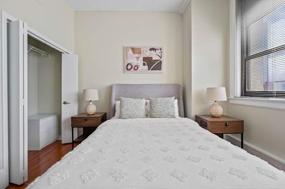 A bedroom with a large bed and two nightstands with lamps.