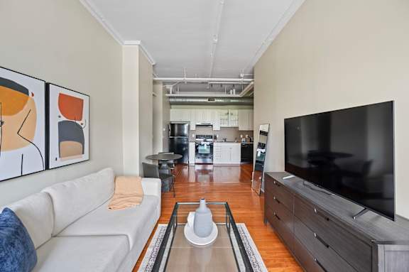A living room with a white couch and a television.