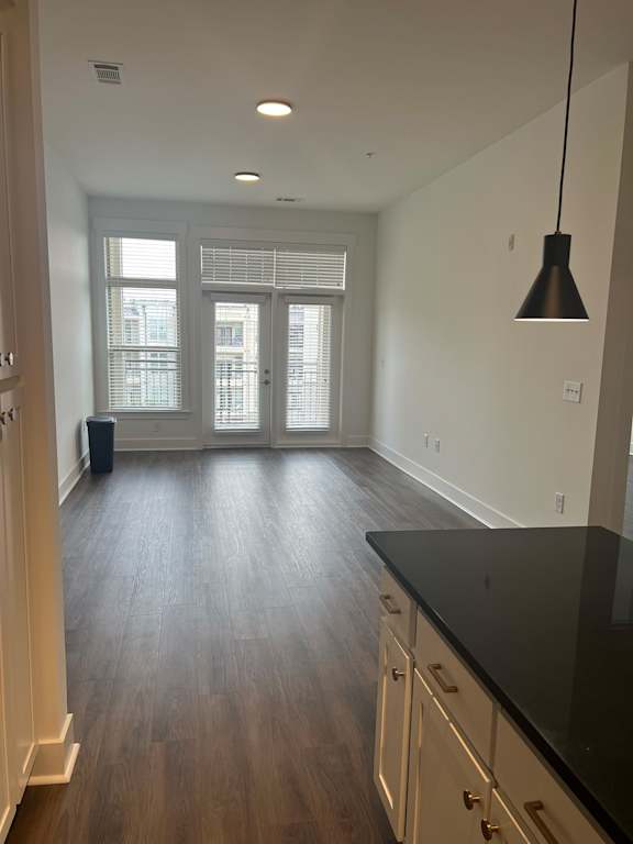 A kitchen with wooden floors and white walls.