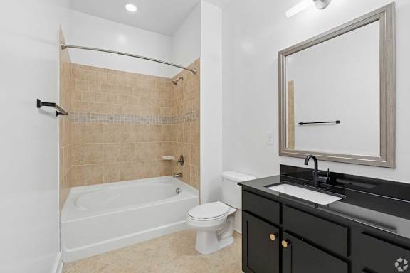 A bathroom with a white tub, sink, and toilet.